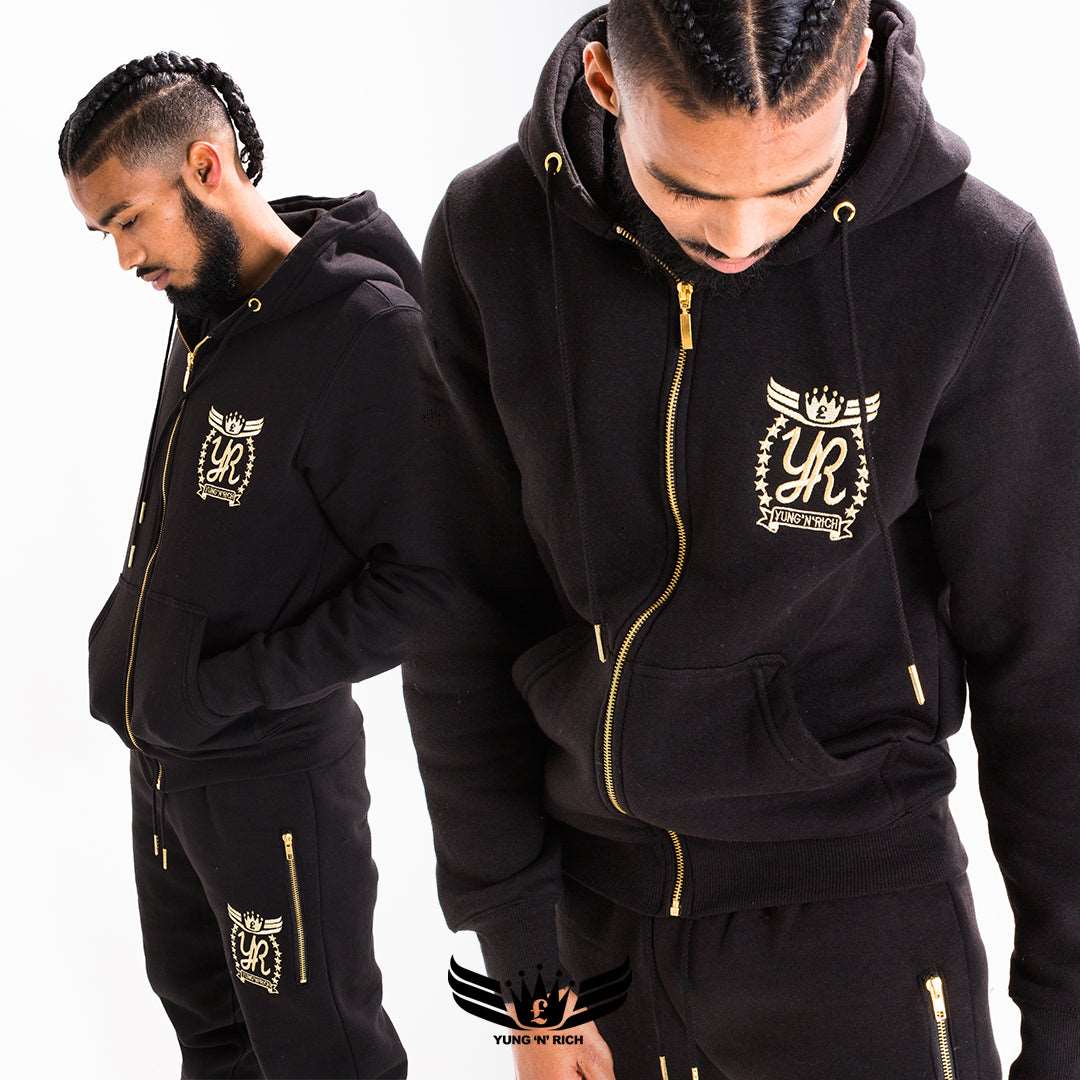 YUNG'N'RICH Gold Edition Black Tracksuit with YNR branding on the left chest & leg, made of cotton, featuring a hoodie, cuffs, and two slit pockets. Exclusively available at YungnRich, representing London's premium streetwear collection for comfortable travel.