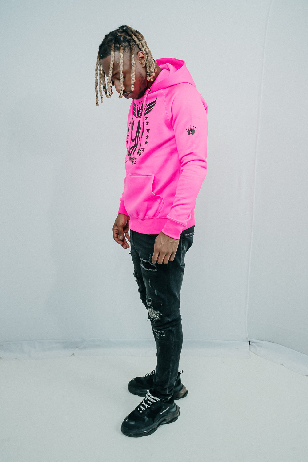 Tizzy Rapper modeling YUNG'N'RICH HOODIE - colour Neon Pink with black rubber Yungnrich logo  side view black rubber crown on sleeve  