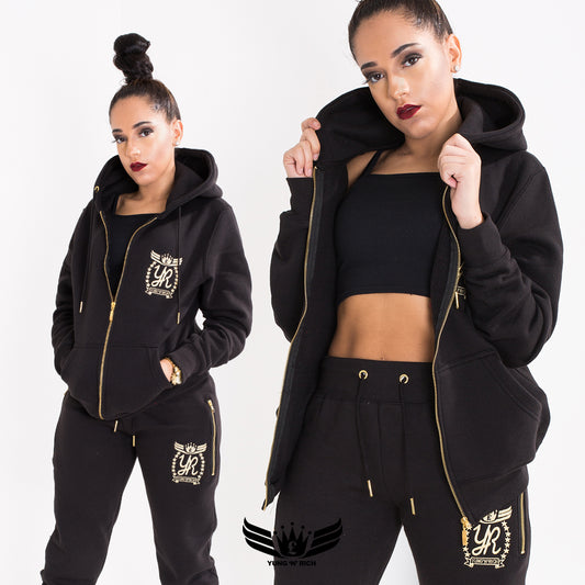 A stylish female confidently wearing the YungnRich Gold Edition Hoodie Tracksuit, showcasing its luxurious design, gold accents, and flattering fit, as she exudes an air of elegance and exclusivity.