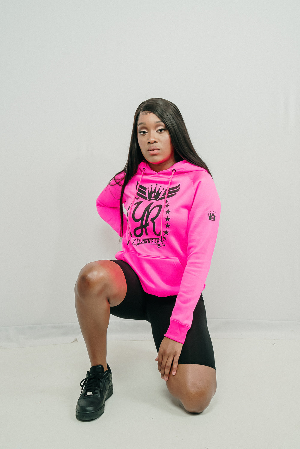 Female  modeling YUNG'N'RICH HOODIE - colour Neon Pink with black rubber Yungnrich logo